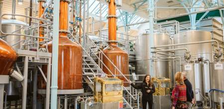 Tour guide explaining the penderyn distillery to a couple