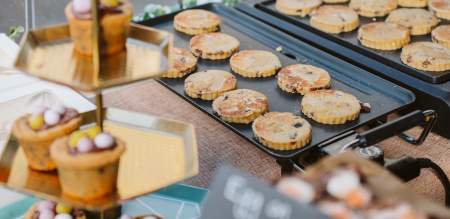 Welsh cakes cooking on a griddle at a local produce market.