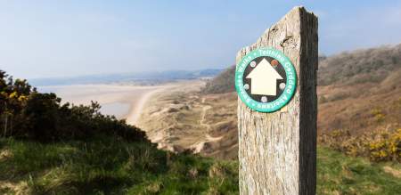 Walking sign post with Crawley beach in the background.