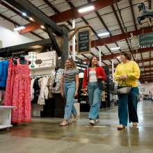 three ladies walking in a large shopping complex