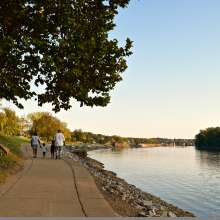 family walking along a riverwalk in the early fall