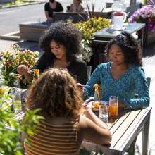 Group of college age friends enjoying Pad Thai outside Nawa restaurant in Fort Wayne.