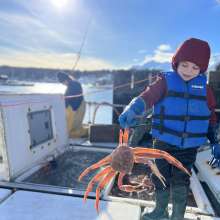 Lucas DeWitt with a tanner crab onboard the F/V Kealailani