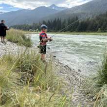 boys fishing along river