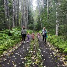 Children walking a trial with moms, fall leaves