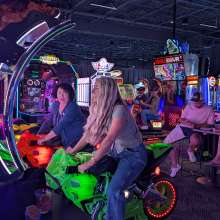 People having fun riding arcade bikes at Dave & Buster's