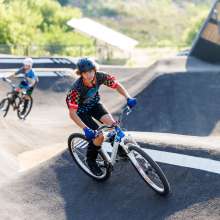 2 kids riding in a pump track