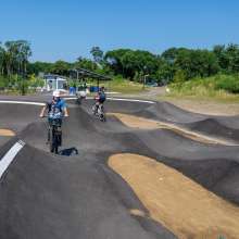 2 riders on bikes using the pump track