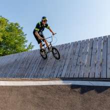 Rider up on curved wall at pump track