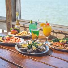 Seafood and colorful drinks with the water in the background