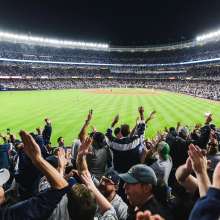 Nighttime game at Yankees stadium with fans cheering