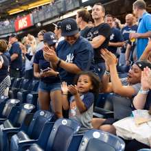 Yankees fans standing to cheer during a game