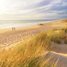 Couple walking along the sand at Preston Beach in Waroona