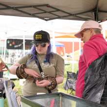 Women holding a snake at an Earth Day Festival
