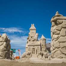 Halloween Haunted House Sand Sculpture with jack o lanterns and ghosts coming out of the top window.