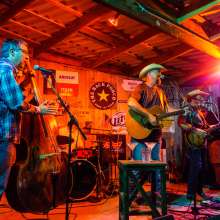 A band performs on a stage washed in orange light