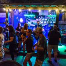 A group dances in front of a band playing on a small stage.