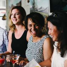 A group of people sitting at a bar smiling