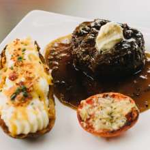 A plate of steak with a potato