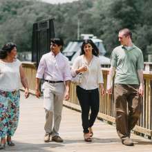 Two women and two women walking along a bridge