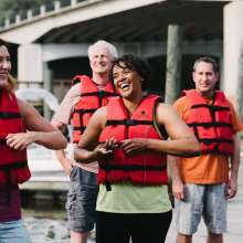 A group of people putting on life jackets