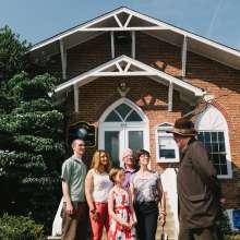 A family listening to a story in front of town hall in Occoquan