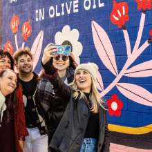 friends taking a selfie in front of a mural at Mural Park in the Royal Square District of Downtown York