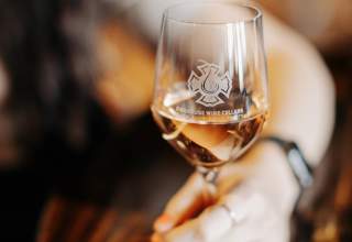 Woman holding wine glass filled with white wine from local winery Firehouse Wine Cellars in Rapid City, SD