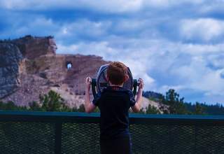 Kid viewing the memorial from the viewing deck at Crazy Horse Memorial