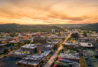 Drone shot overlooking downtown Rapid City with sunset in the background