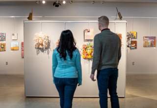 couple looking at the art on display in the suzie cappa art gallery