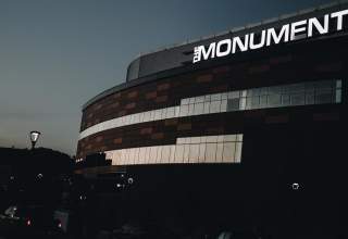 The Monument signage lit up on the exterior of the summit arena in rapid city south dakota