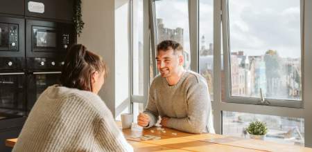 A young man and woman at a kitchen table.