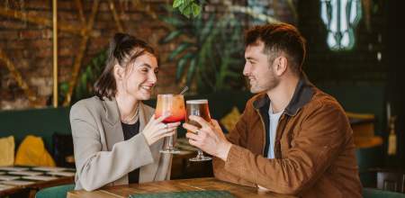 A couple enjoy cocktails at a bar