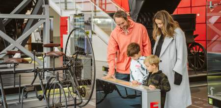 A man, woman and two boys looking at an exhibit in a museum.