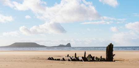 Rhossili beach with the wreck of the Helvetia in the background.