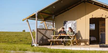 Couple sitting outside of a glamping pod having breakfast