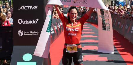 Winner of the Swansea Ironman holding the finishing ribbon