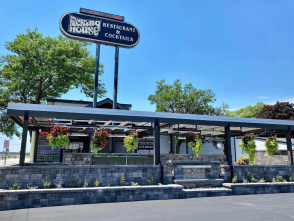 Exterior view of the Packing House restaurant and cocktail lounge with outdoor seating and hanging flower baskets.