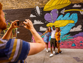 friends taking a picture in front of a colorful mural