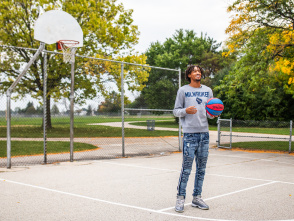 Learic Davis on an outdoor public basketball court, smiling and holding a basketball