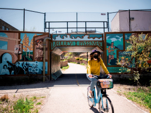 woman biking under Valley Passage Bridge