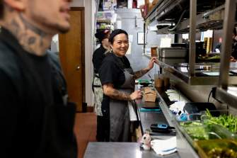 A southeast Asian woman. chef Jamie Brown-Soukaseume, stands in the kitchen at Ahan and looks to the camera.