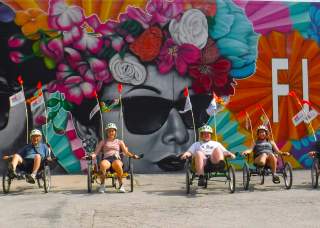 Cyclists on bike tour in front of San Antonio mural