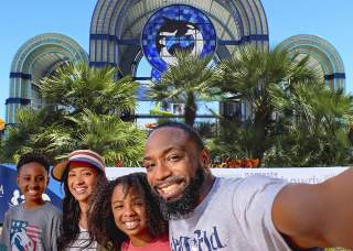 Family taking selfie in front of SeaWorld San Antonio arches
