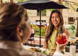 Woman accepting drink from waitress and smiling