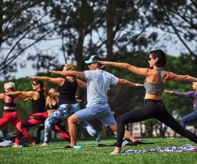 People doing Yoga poses at Iheart Yoga In the Park
