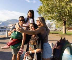 Family posing with Ogopogo statue in Kelowna