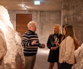 Group_Listening_to_a_Guide_While_Holding_Wine_Glasses_Inside_the_Wine_Caves