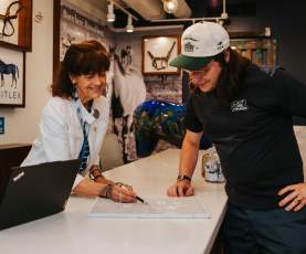 A visitor information specialist assisting a visitor at the counter